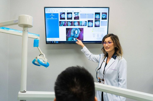 Dr. Christianne Lee reviewing intraoral photographs of a patient's teeth at Irvine Dentistry in Irvine, California.