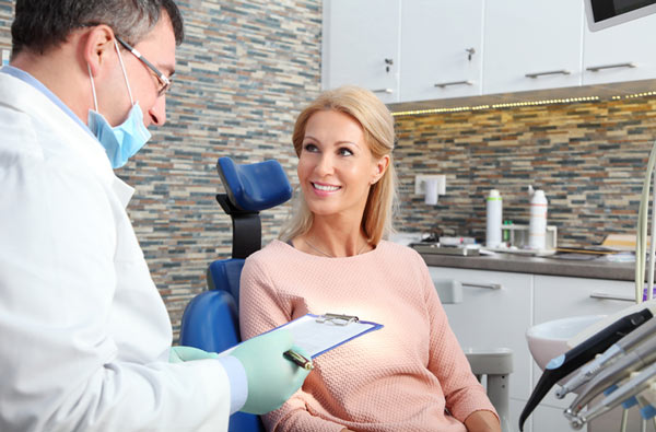 Woman talking to dentist during dental exam at Irvine Dentistry in Irvine, California.