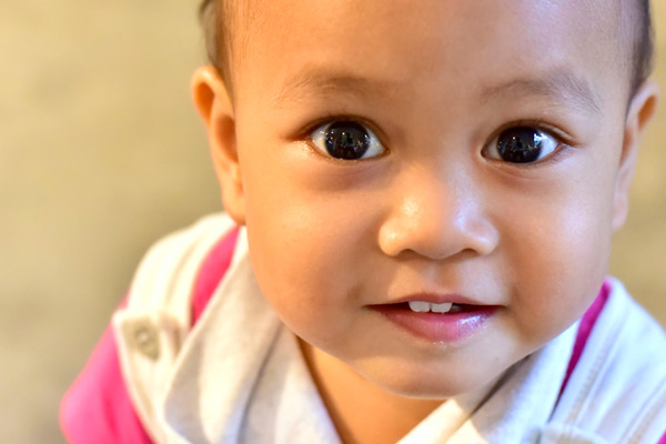 Close up image of a baby girl with teeth at Irvine Dentistry.